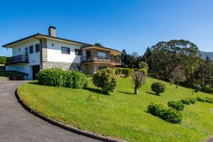 a house on a grassy hill with a driveway at Finca Tolombreo Casa Gabriel in Cudillero