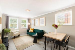 a living room with a green couch and a table at Modern 2-Bedroom Apartments with Free Parking in Leamington Spa in Leamington Spa
