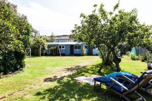 a yard with two chairs and a house at The Studio Christchurch B&B Luxury Garden Room in Christchurch