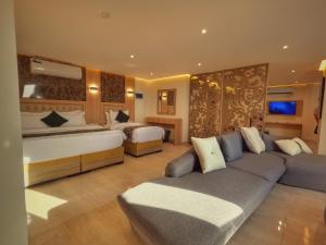 a hotel room with two beds and a couch at Grand Season Hotel in Aqaba
