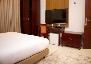 a bedroom with a bed and a desk with a television at الموج للشقق الفندقية in Falaj al Qabāʼil