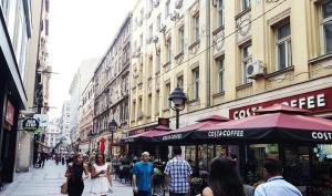 Un groupe de personnes marchant dans une rue urbaine animée dans l'établissement Apartments Centro, à Belgrade