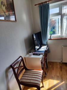 silla y escritorio en una habitación con ventana en simply guesthouse, en Londres