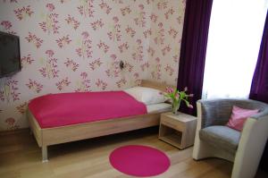 niewielka sypialnia z łóżkiem i krzesłem w obiekcie Waldhotel Bad Münstereifel w mieście Bad Münstereifel