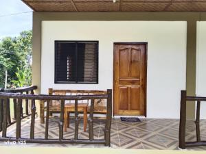 a porch of a house with a wooden door at Casa James Apartment, Rooms , Pool and Restaurant in Siquijor