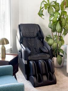 a black leather reclining chair in a living room with a plant at Quaint Mid-Century Cottage by the Coast in Ventura