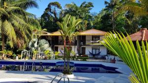 a resort with a pool and palm trees at Hotel Palma Real in Playa Ladrilleros