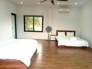 a bedroom with two beds and a window and a fan at Green Meadow Villa in Hanoi +55 photos