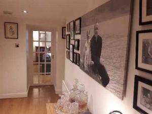 a living room with a bunch of pictures on the wall at The Garden Flat in Windermere