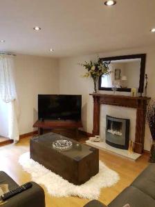 a living room with a couch and a fireplace at The Garden Flat in Windermere