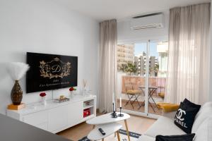 een woonkamer met een witte bank en een tv bij Marea Living Marbella in Marbella