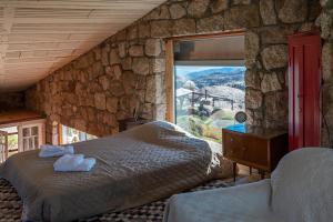 a bedroom with a bed and a large window at Rustic Mountain Shelter Pure Nature in Las Rabonas
