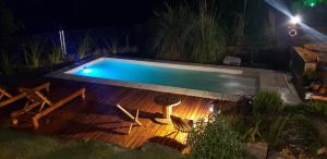 a swimming pool in a yard at night at Albero Suites Serranas in Valle Hermoso