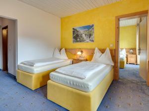 two beds in a room with yellow walls at Bergjuwel Typ 5 in Fügen