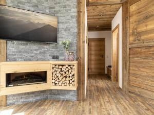 a living room with a fireplace and a flat screen tv at Bergjuwel in Fügen