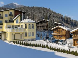 a building with cars parked in front of it in the snow at Bergjuwel in Fügen