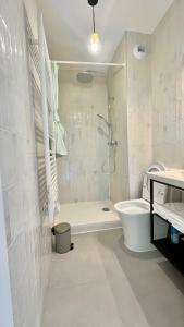 a white bathroom with a shower and a toilet at Maison 88 Malakoff in Malakoff