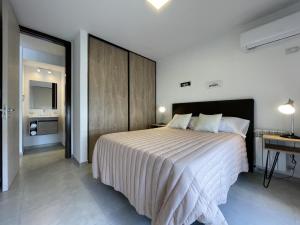 a bedroom with a large bed and a desk at Depto Paseo Quattro in Villa Carlos Paz +5 photos