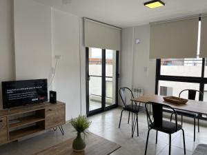 a living room with a dining room table and a television at Depto Paseo Quattro in Villa Carlos Paz