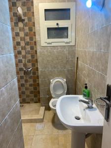 a bathroom with a sink and a toilet and a window at Agora Sidi Abdelrahman - One Bedroom Chalet in El Alamein