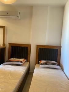 two beds sitting next to each other in a room at Agora Sidi Abdelrahman - One Bedroom Chalet in El Alamein