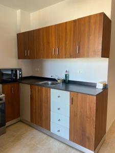 a kitchen with wooden cabinets and a sink at Agora Sidi Abdelrahman - One Bedroom Chalet in El Alamein