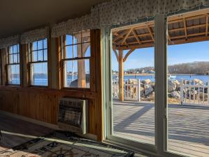 a room with windows and a view of the water at Beach Cottage in Saco