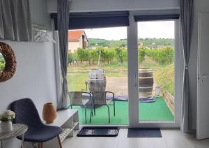 a room with a door open to a patio with chairs at Lugas Apartman in Villány +41 photos