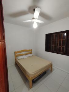 a bedroom with a bed and a ceiling fan at Sitio canários 4 in Maricá
