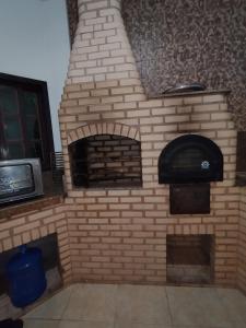 an outdoor brick oven with a tv in it at Sitio canários 4 in Maricá