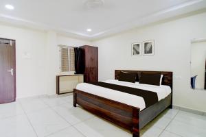 a bedroom with a large bed in a room at Hotel O Ramavarapadu Near PVR Icon in Vijayawada