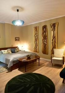 a bedroom with a bed and a table and a chair at Tornácos Vendégház Kőröshegy in Kőröshegy