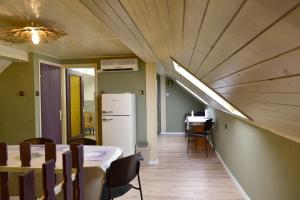a dining room with a table and a refrigerator at Tornácos Vendégház Kőröshegy in Kőröshegy