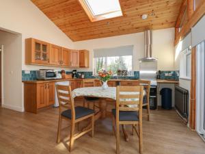 Una cocina con mesa y sillas y una ventana. en Ty Golchi, en Bangor