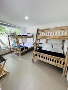 a room with three bunk beds and a window at Finca de lujo con picsina en San Jerónimo Antioquia in San Jerónimo