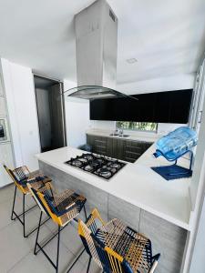 a kitchen with a counter with chairs and a stove at Finca de lujo con picsina en San Jerónimo Antioquia in San Jerónimo
