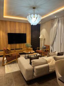 a living room with a couch and a tv at Apartment Opal At The Park in Accra