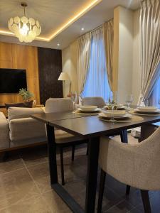 a dining table and chairs in a living room at Apartment Opal At The Park in Accra +16 photos