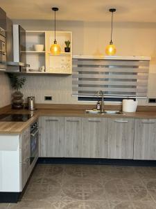 a kitchen with wooden cabinets and a sink at Apartment Opal At The Park in Accra