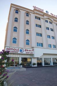 a large building with a sign in front of it at الموج للشقق الفندقية in Falaj al Qabāʼil +10 photos