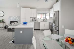 une cuisine avec des armoires blanches et une table en verre dans l'établissement Fairbrook Home - Chic Design Saltwater Pool with Hot Tub, à Mesa