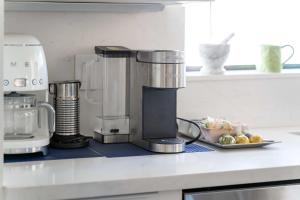 - un comptoir de cuisine avec une cafetière et une assiette de fruits dans l'établissement Fairbrook Home - Chic Design Saltwater Pool with Hot Tub, à Mesa