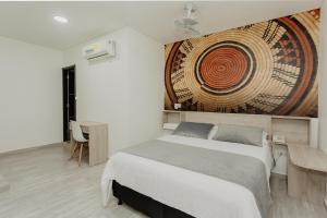 una camera da letto con un letto e un grande dipinto sul muro di Hotel Plataneras Caney a Turbo