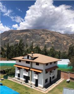 a model of a house with a mountain in the background at Lodge Acopampa Inn in Carhuaz