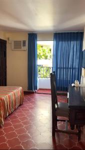 a hotel room with a bed and a desk and a window at Hotel Gaviota Vallarta in Puerto Vallarta