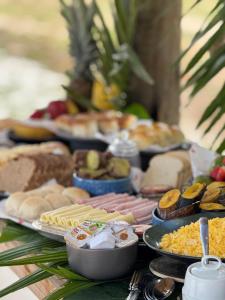 una tabella ricoperta con diversi tipi di alimenti su piatti di Kokar Casa Hotel - Santo André a Santa Cruz Cabrália Altre 60 foto