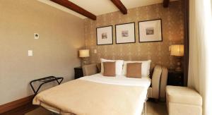 Un dormitorio con una cama grande y una silla. en BUONA VITTA Gramado Apto 413, en Gramado