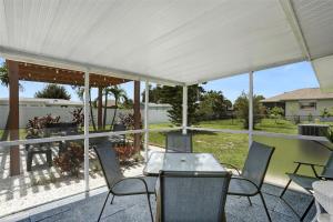 porche cubierto con mesa y sillas en Close To Beach! 3 Bedroom 2 Bath, en Englewood