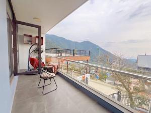 a balcony with a chair and a view of a mountain at Bon villa tam đảo in Tam Ðảo