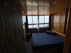 een kleine slaapkamer met een bed in een boot bij Aamo Homestay in Darjeeling +2 foto's